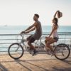 Portrait,Of,A,Mixed,Race,Couple,Riding,On,Tandem,Bicycle
